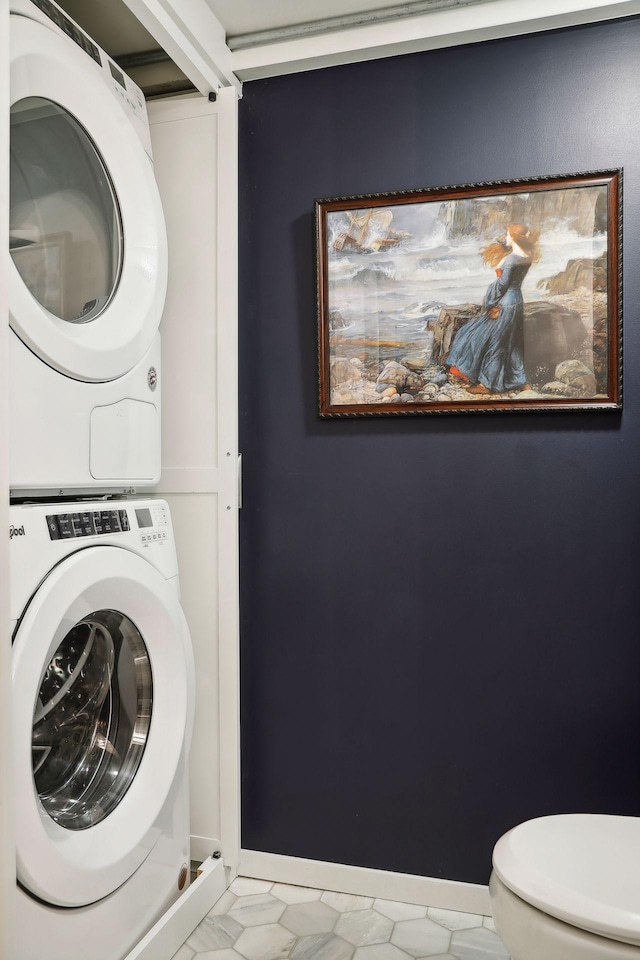 clothes washing area with light tile floors and stacked washer and dryer