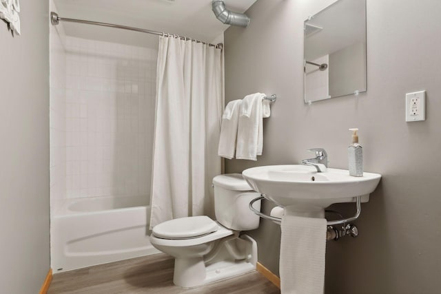 bathroom featuring wood-type flooring, toilet, and shower / bathtub combination with curtain