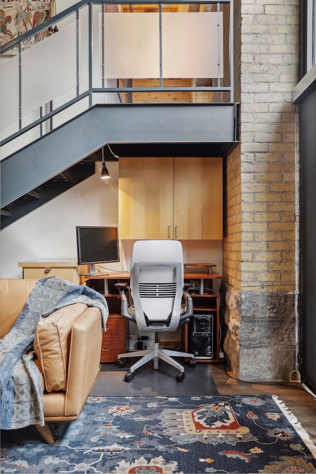 office with dark wood-type flooring and high vaulted ceiling