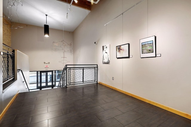 unfurnished room with high vaulted ceiling and beam ceiling