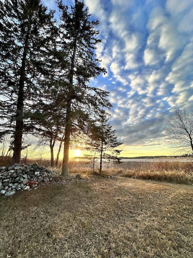 yard at dusk featuring a rural view