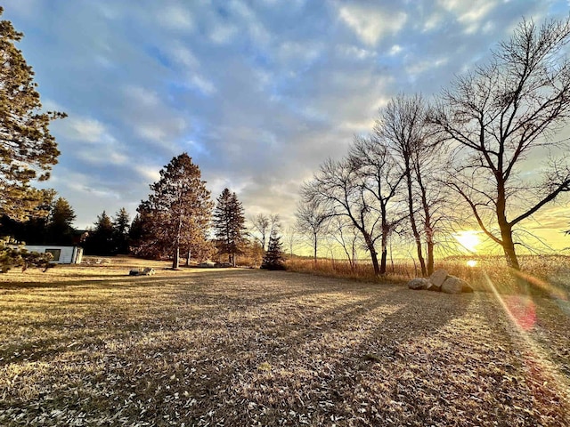 yard at dusk featuring a rural view