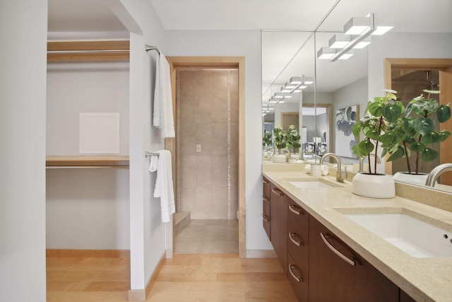 bathroom featuring vanity, a tile shower, and hardwood / wood-style flooring