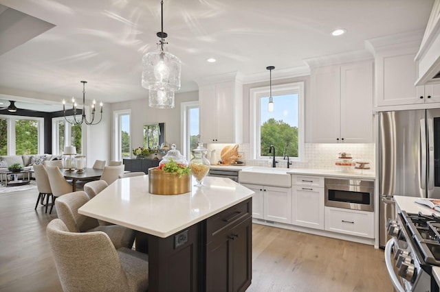 kitchen featuring plenty of natural light, tasteful backsplash, light hardwood / wood-style flooring, and sink