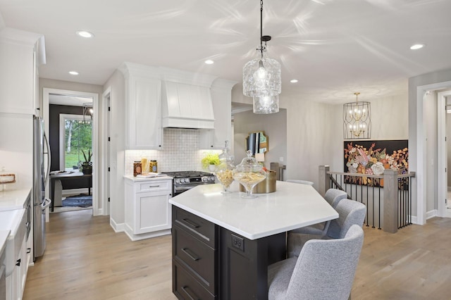 kitchen featuring pendant lighting, light wood-type flooring, custom exhaust hood, and white cabinets