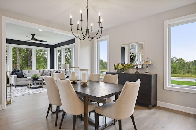 dining area featuring ceiling fan with notable chandelier and light wood-type flooring