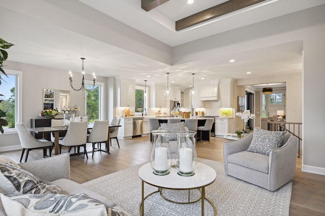 living room featuring an inviting chandelier, light hardwood / wood-style flooring, and a wealth of natural light