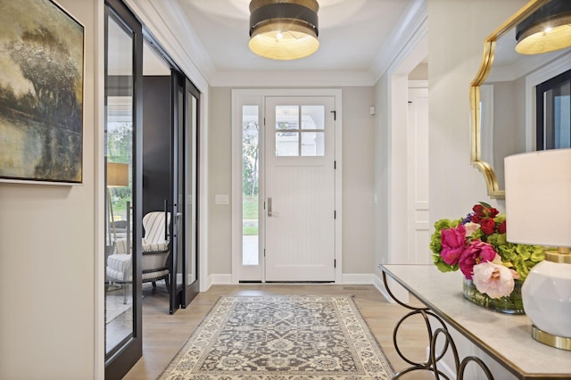 entrance foyer featuring ornamental molding and light hardwood / wood-style flooring