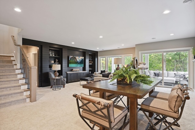 dining space featuring built in features and light colored carpet