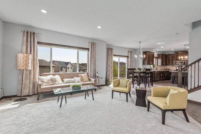 carpeted living room featuring a notable chandelier