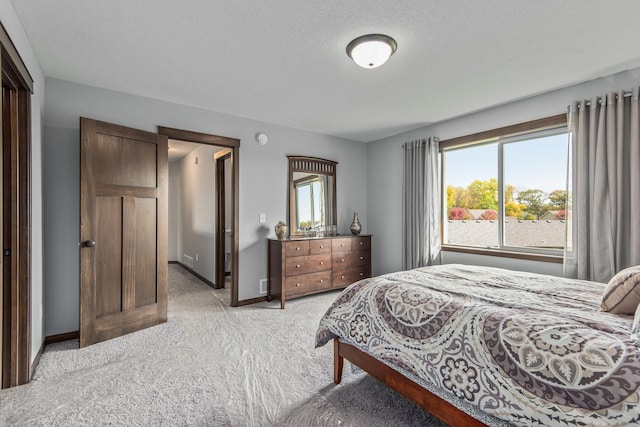 bedroom with light carpet and a textured ceiling