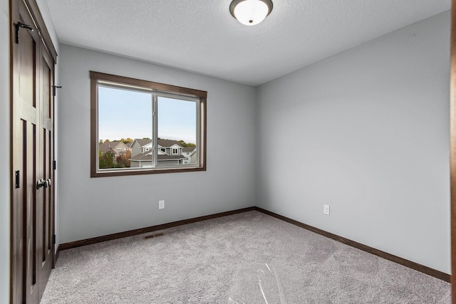 unfurnished bedroom featuring light colored carpet and a textured ceiling