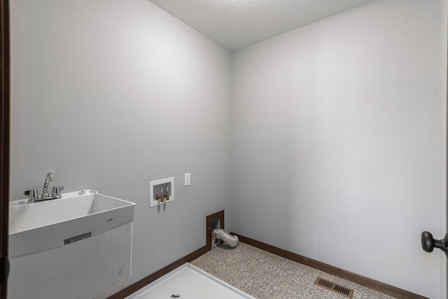 washroom featuring hookup for a washing machine and a textured ceiling