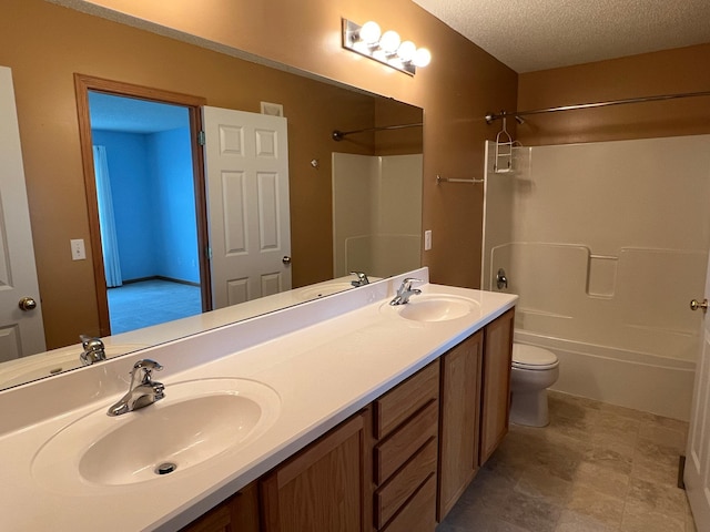 full bathroom featuring toilet, vanity, bathing tub / shower combination, and a textured ceiling