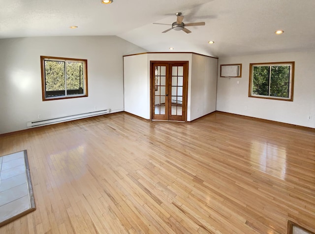 unfurnished room with baseboard heating, plenty of natural light, light hardwood / wood-style floors, and french doors