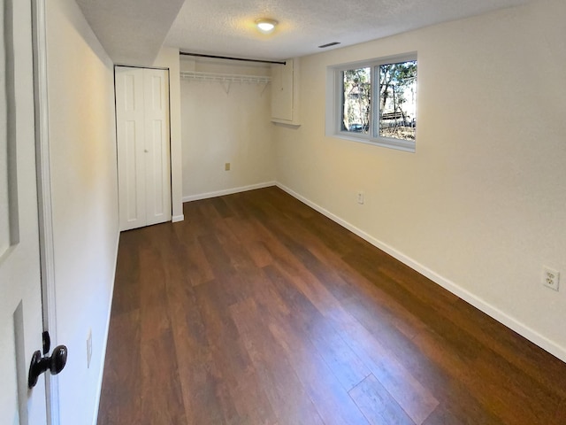 unfurnished bedroom with dark hardwood / wood-style floors, a textured ceiling, and a closet