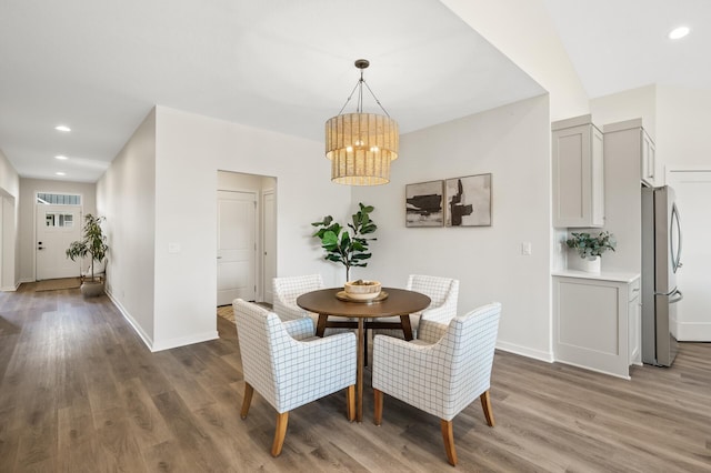 dining space with wood-type flooring and a notable chandelier