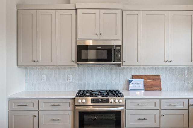 kitchen with stainless steel appliances and decorative backsplash