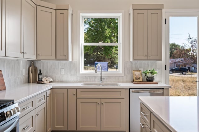 kitchen with gray cabinetry, stainless steel appliances, decorative backsplash, and sink