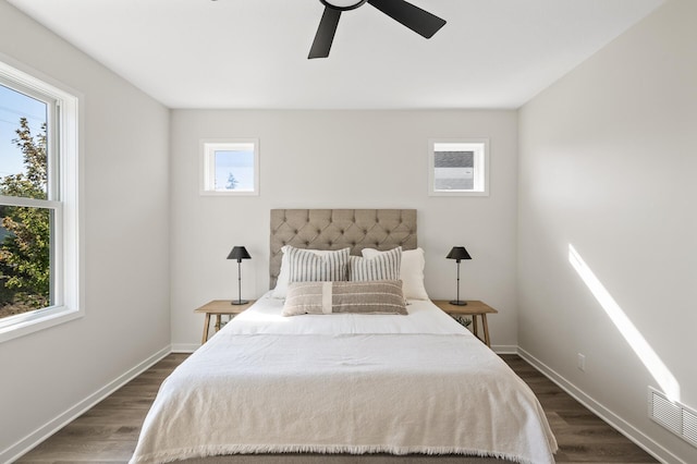 bedroom featuring multiple windows, dark hardwood / wood-style flooring, and ceiling fan