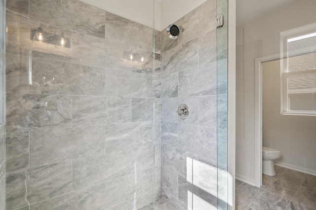 bathroom featuring tiled shower and toilet