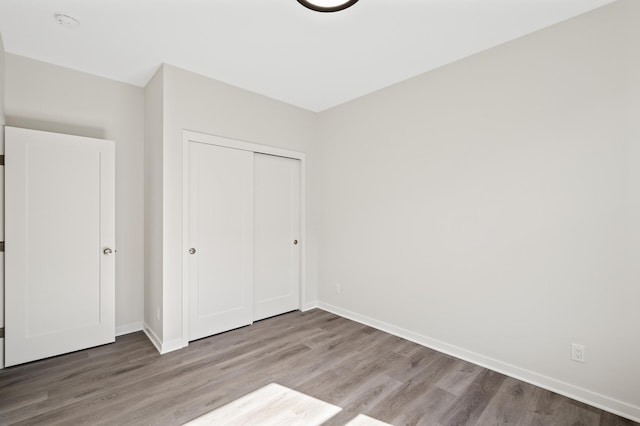 unfurnished bedroom with a closet and hardwood / wood-style floors