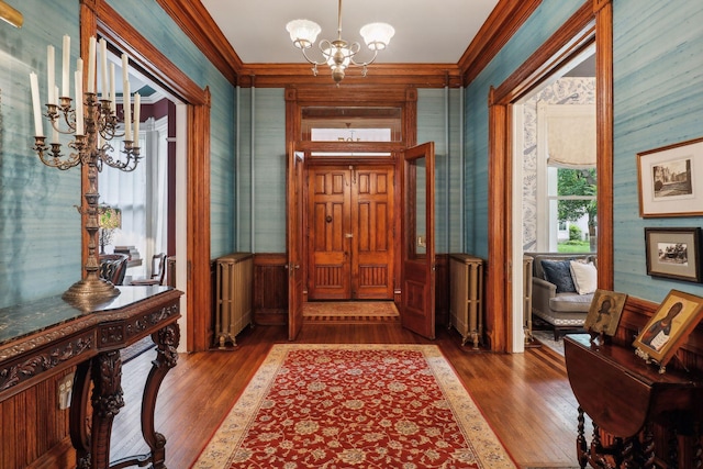 entryway featuring a notable chandelier, dark hardwood / wood-style floors, crown molding, and radiator