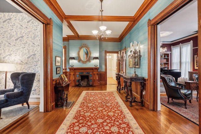 corridor featuring hardwood / wood-style floors, ornamental molding, and a notable chandelier