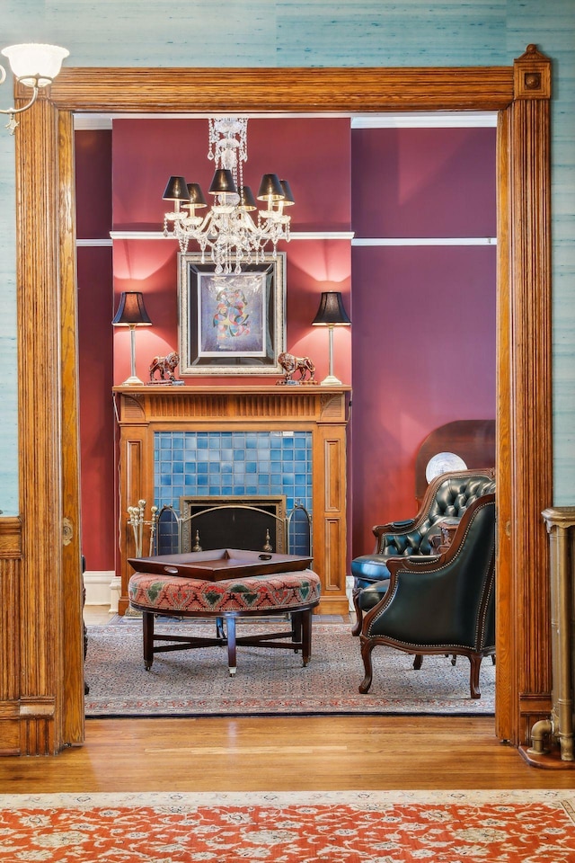 sitting room with a tile fireplace and hardwood / wood-style flooring