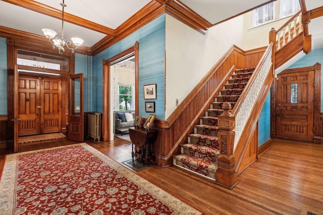 foyer with a chandelier, hardwood / wood-style flooring, and ornamental molding