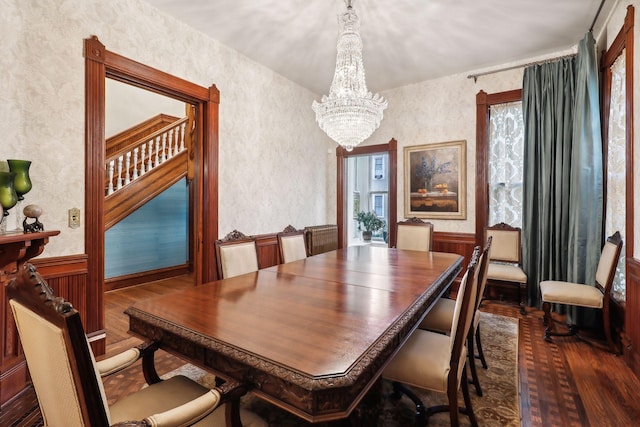 dining space with a chandelier, a healthy amount of sunlight, and dark wood-type flooring