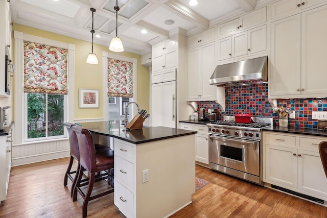 kitchen featuring coffered ceiling, premium appliances, a kitchen island with sink, pendant lighting, and a breakfast bar area