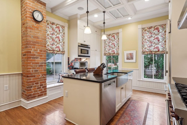 kitchen featuring sink, hanging light fixtures, a center island with sink, white cabinets, and appliances with stainless steel finishes