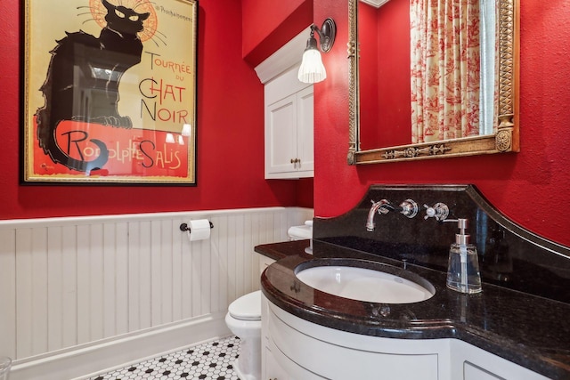 bathroom with tile patterned flooring, vanity, and toilet