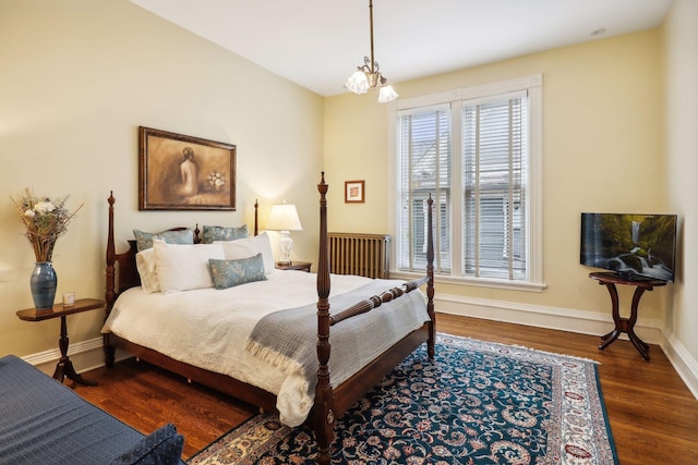 bedroom featuring a notable chandelier and dark wood-type flooring