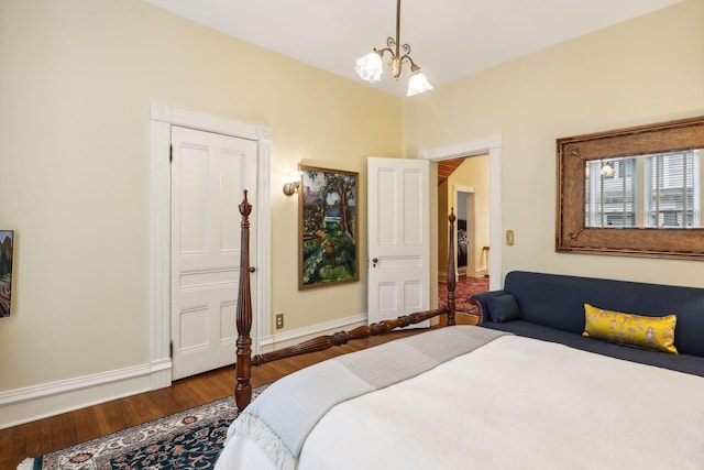 bedroom with dark hardwood / wood-style flooring and a chandelier