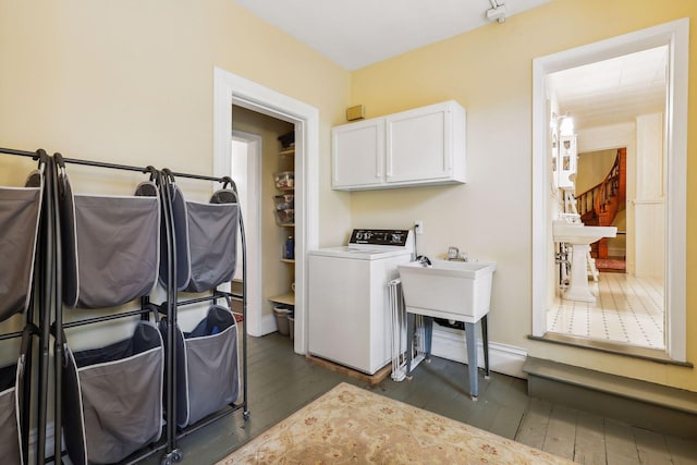 laundry room featuring washer / clothes dryer, dark hardwood / wood-style flooring, and cabinets