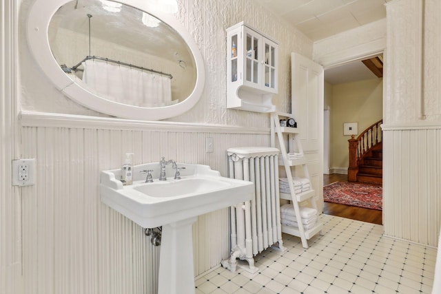 bathroom with wood-type flooring, sink, and radiator