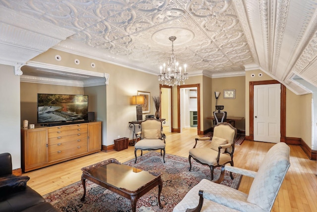 living room featuring hardwood / wood-style flooring, ornamental molding, and a chandelier