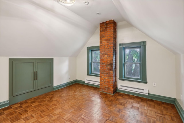 additional living space featuring parquet flooring, vaulted ceiling, and a baseboard heating unit