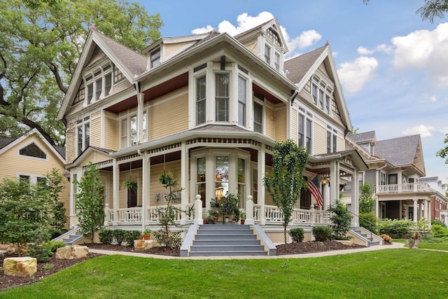 victorian home with covered porch and a front yard