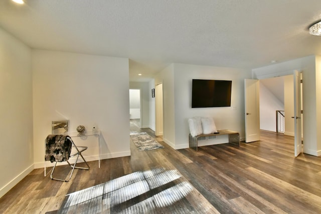 interior space featuring a textured ceiling and dark wood-type flooring