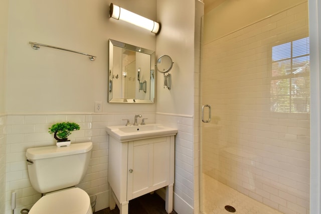 bathroom featuring tile walls, large vanity, toilet, and an enclosed shower