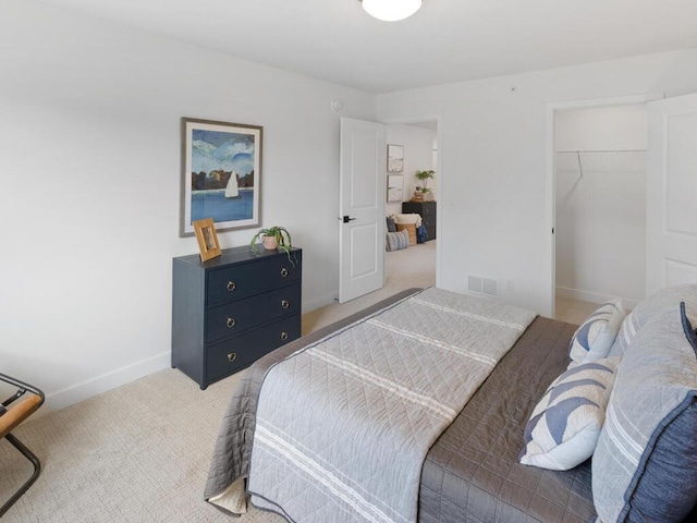 carpeted bedroom featuring a spacious closet and a closet