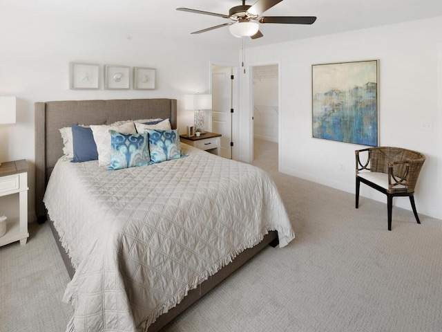 carpeted bedroom featuring a walk in closet, ceiling fan, and a closet