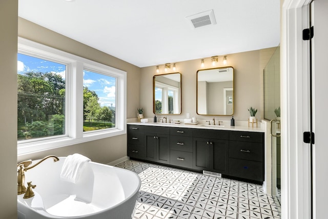 bathroom featuring a washtub, vanity, and tile patterned flooring