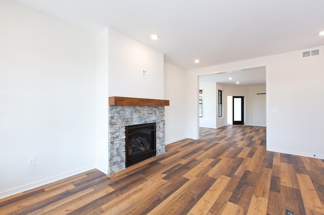 unfurnished living room featuring dark hardwood / wood-style flooring and a fireplace