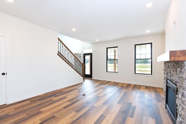 unfurnished living room featuring a fireplace and dark wood-type flooring