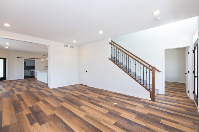 unfurnished living room featuring dark hardwood / wood-style flooring and sink