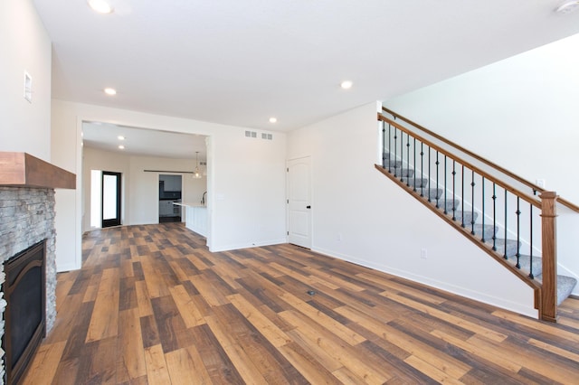 unfurnished living room featuring dark hardwood / wood-style flooring and a fireplace